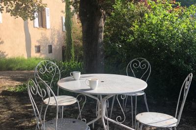 Table en bois décorée pour un repas festif, avec bougies, fleurs et vaisselle, dans une salle aux murs en pierre.