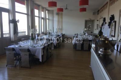 Réfrigérateur professionnel ouvert avec plusieurs étagères métalliques vides dans un environnement de cuisine.