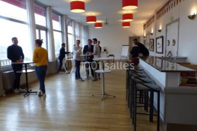 Réfrigérateur professionnel ouvert avec plusieurs étagères métalliques vides dans un environnement de cuisine.