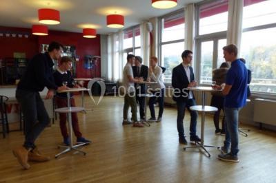 Réfrigérateur professionnel ouvert avec plusieurs étagères métalliques vides dans un environnement de cuisine.