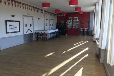 Réfrigérateur professionnel ouvert avec plusieurs étagères métalliques vides dans un environnement de cuisine.