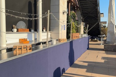 Salle de conférence moderne avec des chaises pliantes alignées face à un écran de projection.