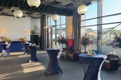 Salle de conférence moderne avec des chaises pliantes alignées face à un écran de projection.