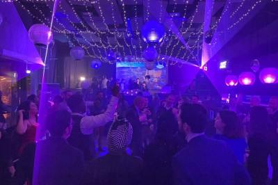 Salle de conférence moderne avec des chaises pliantes alignées face à un écran de projection.