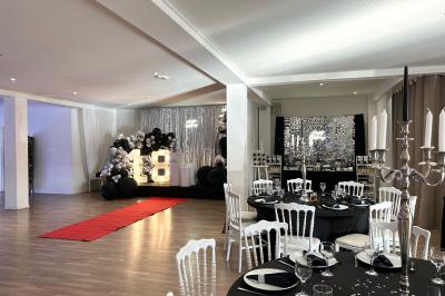 Buffet garni de plats variés sur une longue table blanche, dans une salle décorée avec des ballons suspendus.