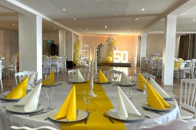 Buffet garni de plats variés sur une longue table blanche, dans une salle décorée avec des ballons suspendus.