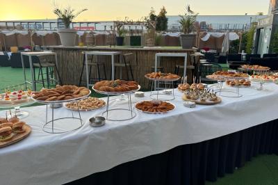 Buffet garni de plats variés sur une longue table blanche, dans une salle décorée avec des ballons suspendus.
