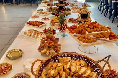 Buffet garni de plats variés sur une longue table blanche, dans une salle décorée avec des ballons suspendus.