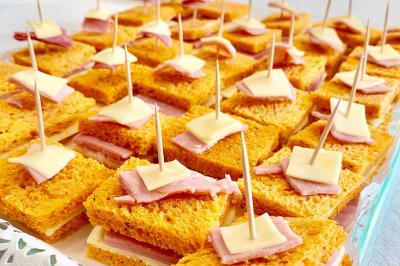 Buffet garni de plats variés sur une longue table blanche, dans une salle décorée avec des ballons suspendus.