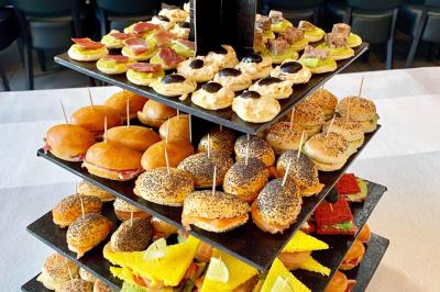 Buffet garni de plats variés sur une longue table blanche, dans une salle décorée avec des ballons suspendus.