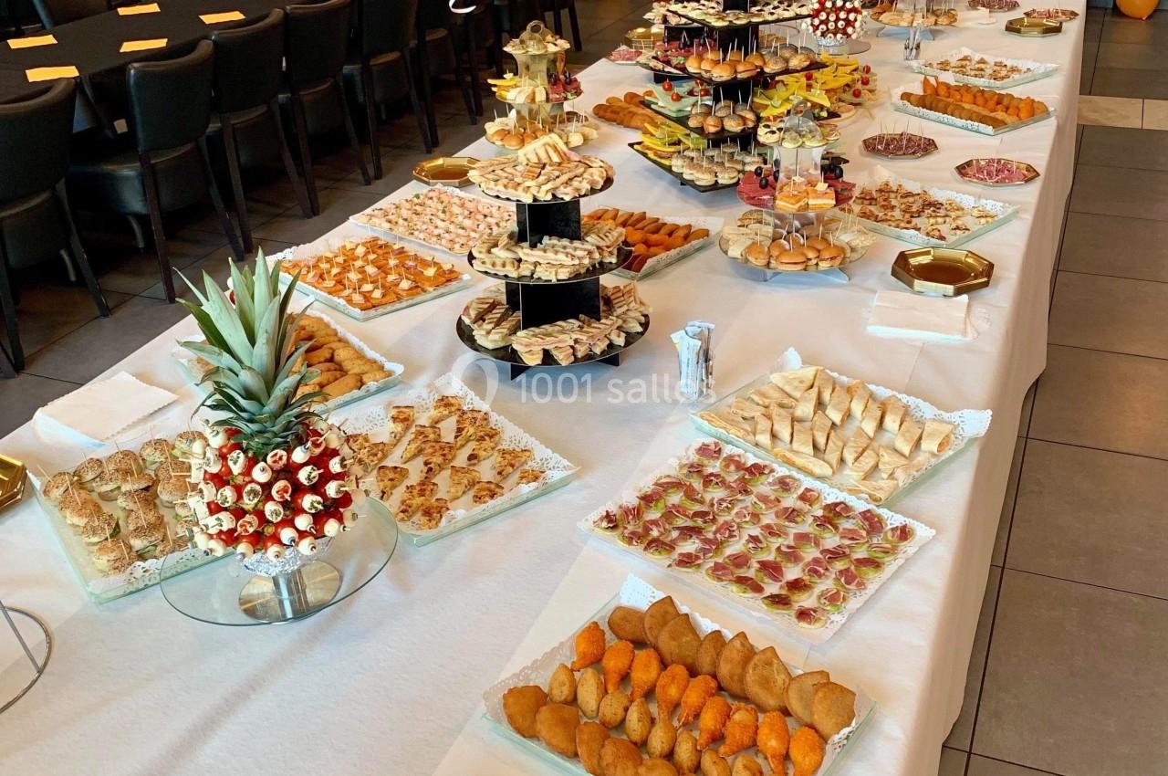 Buffet de réception avec une grande variété de plats salés et sucrés disposés sur des tables décorées.