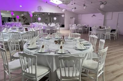 Buffet garni de plats variés sur une longue table blanche, dans une salle décorée avec des ballons suspendus.