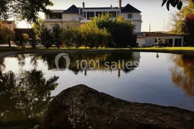 Décoration de salle de réception avec éclairage rose, rideaux, chandeliers et ornements lumineux en forme de cœur.