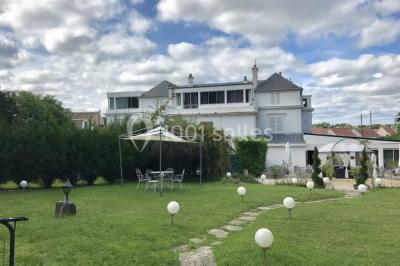 Décoration de salle de réception avec éclairage rose, rideaux, chandeliers et ornements lumineux en forme de cœur.