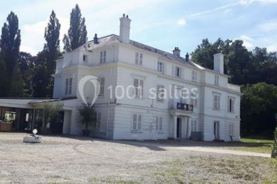 Décoration de salle de réception avec éclairage rose, rideaux, chandeliers et ornements lumineux en forme de cœur.
