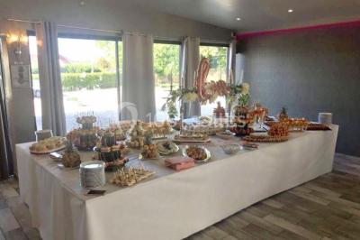 Décoration de salle de réception avec éclairage rose, rideaux, chandeliers et ornements lumineux en forme de cœur.