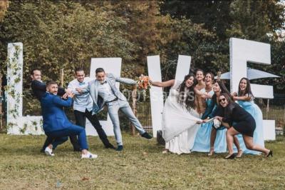 Décoration de salle de réception avec éclairage rose, rideaux, chandeliers et ornements lumineux en forme de cœur.