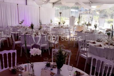 Décoration de salle de réception avec éclairage rose, rideaux, chandeliers et ornements lumineux en forme de cœur.