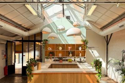 Salon chaleureux avec canapé jaune, fauteuils en rotin, table basse ronde, lampes et décorations murales abstraites.