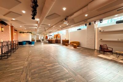 Salon chaleureux avec canapé jaune, fauteuils en rotin, table basse ronde, lampes et décorations murales abstraites.