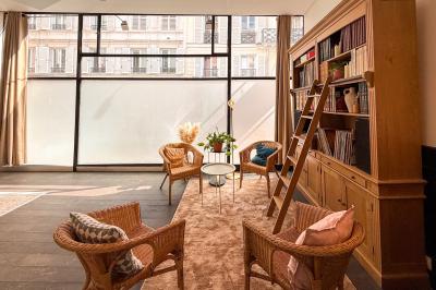 Salon chaleureux avec canapé jaune, fauteuils en rotin, table basse ronde, lampes et décorations murales abstraites.