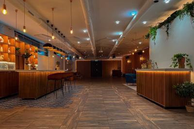 Salon chaleureux avec canapé jaune, fauteuils en rotin, table basse ronde, lampes et décorations murales abstraites.