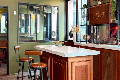 Salon cosy avec canapé jaune, fauteuils en rotin, table basse ronde, lampes et décorations murales dans une ambiance…