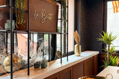 Salon cosy avec canapé jaune, fauteuils en rotin, table basse ronde, lampes et décorations murales dans une ambiance…