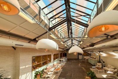 Salon cosy avec canapé jaune, fauteuils en rotin, table basse ronde, lampes et décorations murales dans une ambiance…