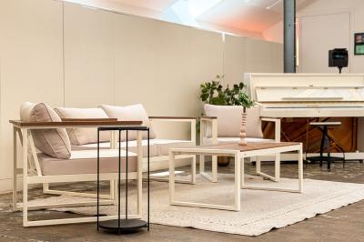 Salon cosy avec canapé jaune, fauteuils en rotin, table basse ronde, lampes et décorations murales dans une ambiance…