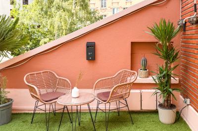 Salon cosy avec canapé jaune, fauteuils en rotin, table basse ronde, lampes et décorations murales dans une ambiance…