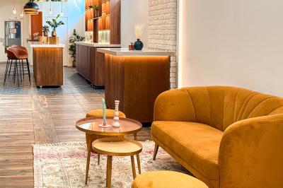 Salon cosy avec canapé jaune, fauteuils en rotin, table basse ronde, lampes et décorations murales dans une ambiance…