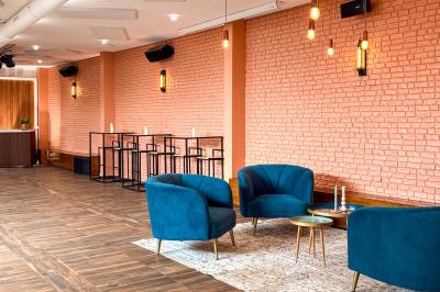 Salon cosy avec canapé jaune, fauteuils en rotin, table basse ronde, lampes et décorations murales dans une ambiance…