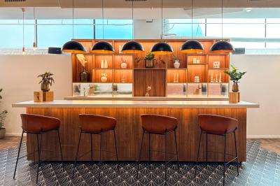 Salon cosy avec canapé jaune, fauteuils en rotin, table basse ronde, lampes et décorations murales dans une ambiance…