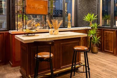 Salon cosy avec canapé jaune, fauteuils en rotin, table basse ronde, lampes et décorations murales dans une ambiance…