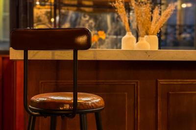 Salon cosy avec canapé jaune, fauteuils en rotin, table basse ronde, lampes et décorations murales dans une ambiance…