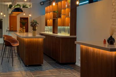 Salon cosy avec canapé jaune, fauteuils en rotin, table basse ronde, lampes et décorations murales dans une ambiance…