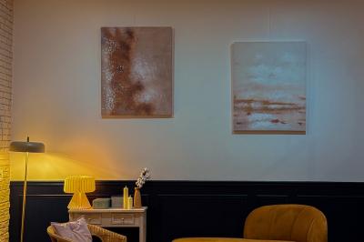 Salon cosy avec canapé jaune, fauteuils en rotin, table basse ronde, lampes et décorations murales dans une ambiance…