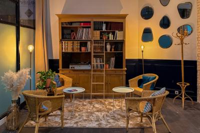 Salon cosy avec canapé jaune, fauteuils en rotin, table basse ronde, lampes et décorations murales dans une ambiance…