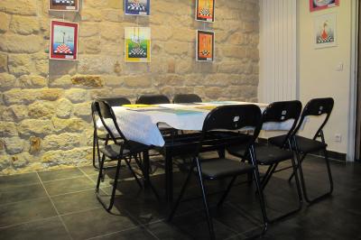 Bar avec comptoir rouge éclairé, tabourets hauts, murs en pierre et briques, décorations murales et étagères avec bouteilles.