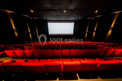 Espace intérieur moderne avec éclairage coloré, affiches promotionnelles et signalétique pour un événement.