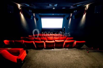 Espace intérieur moderne avec éclairage coloré, affiches promotionnelles et signalétique pour un événement.