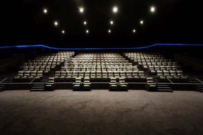 Espace intérieur moderne avec éclairage coloré, affiches promotionnelles et signalétique pour un événement.