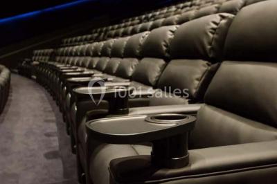 Espace intérieur moderne avec éclairage coloré, affiches promotionnelles et signalétique pour un événement.