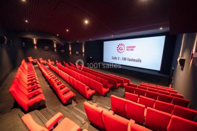 Espace intérieur moderne avec éclairage coloré, affiches promotionnelles et signalétique pour un événement.