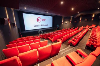 Espace intérieur moderne avec éclairage coloré, affiches promotionnelles et signalétique pour un événement.