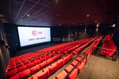 Espace intérieur moderne avec éclairage coloré, affiches promotionnelles et signalétique pour un événement.