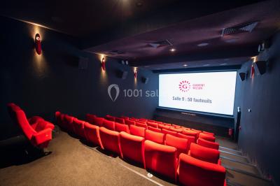 Espace intérieur moderne avec éclairage coloré, affiches promotionnelles et signalétique pour un événement.