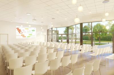 Salle de réception décorée avec des tables rondes, nappes blanches, serviettes orange et centres de table floraux.