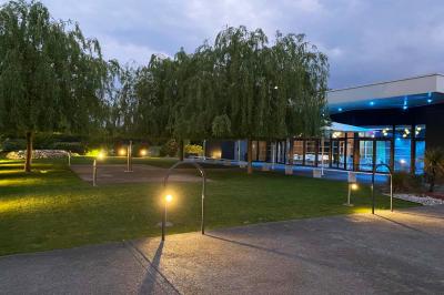 Salle de réception décorée avec des tables rondes, nappes blanches, serviettes orange et centres de table floraux.